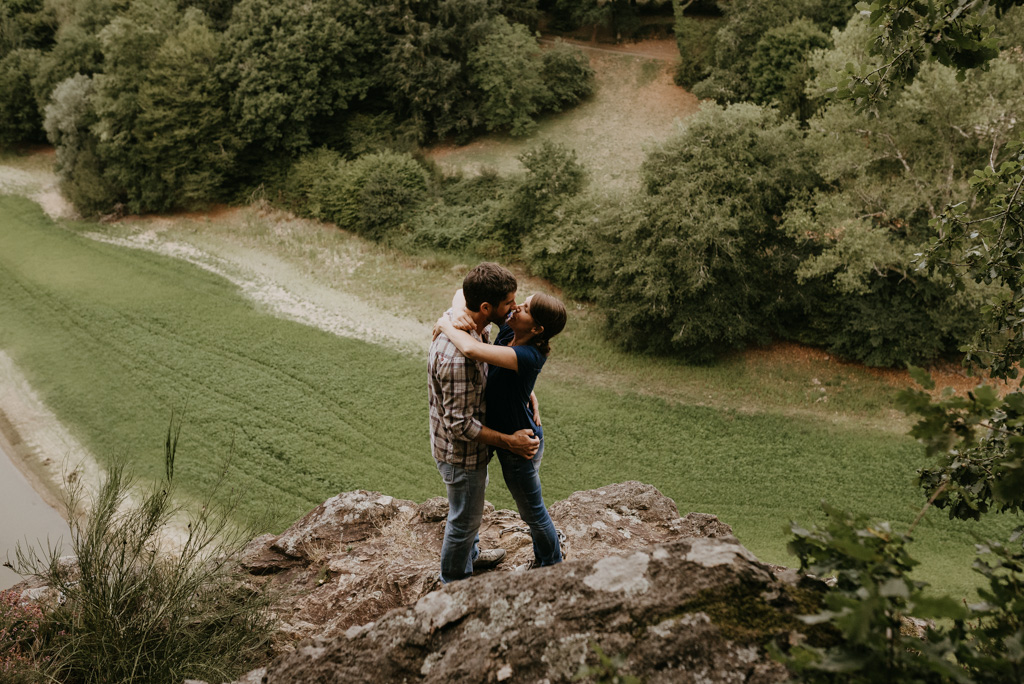 séance engagement Vendée couple rocher au-dessus de la vallée s'embrasse rivière