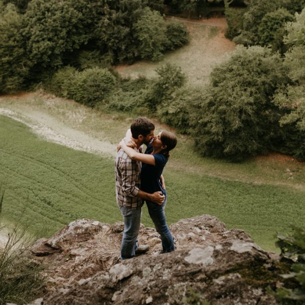 séance engagement Vendée couple rocher au-dessus de la vallée s'embrasse rivière