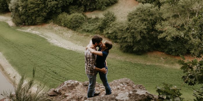 séance engagement Vendée couple rocher au-dessus de la vallée s'embrasse rivière