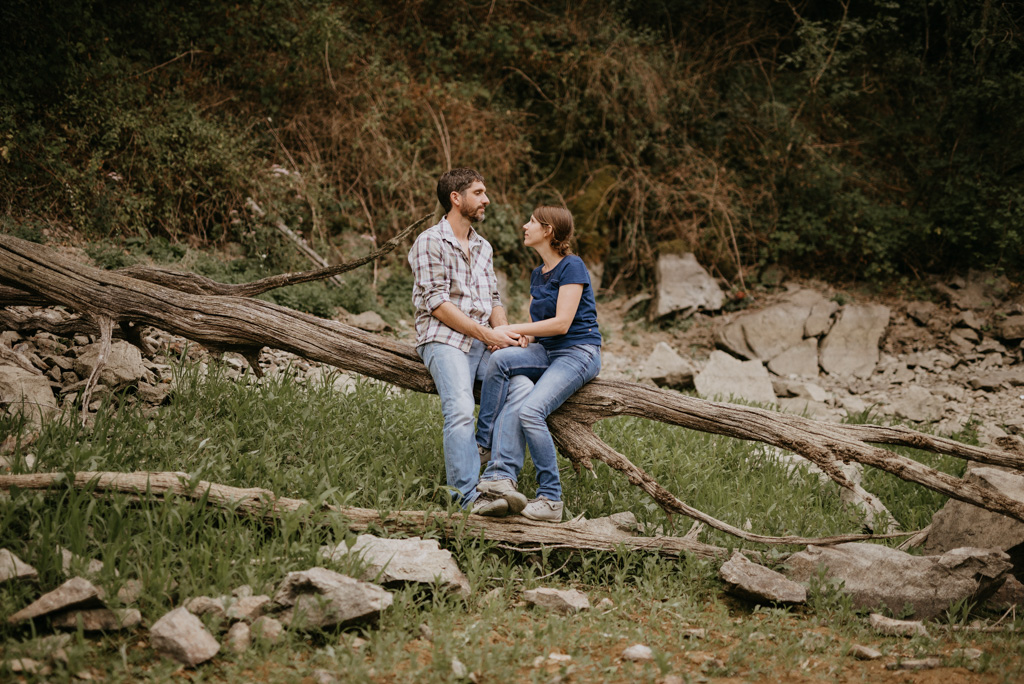 couple se regarde sur un tronc engagement mains