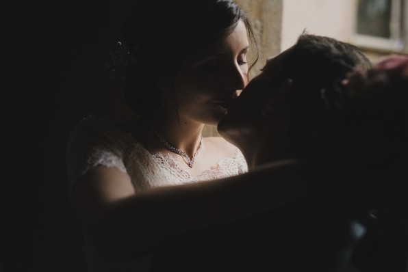 couple mariés s'embrassent clair-obscur robe dentelle