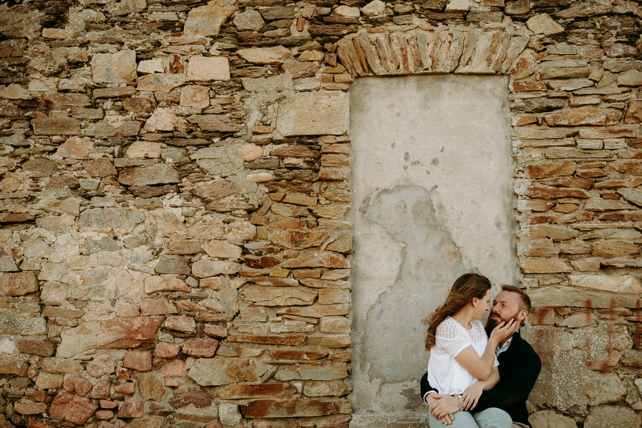 couple assis maison pierre porte caresse visage