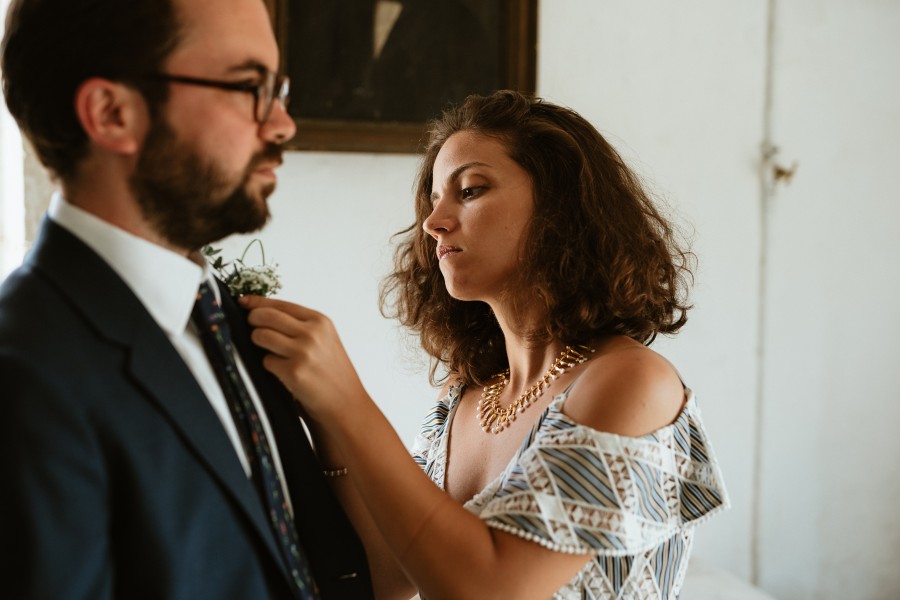 témoin jeune femme fixe boutonnière costume marié