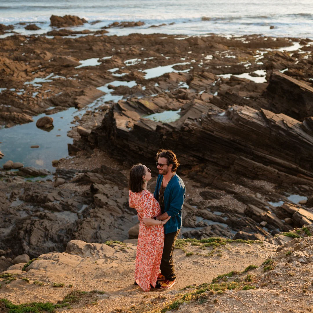 Un couple se regardant sur la côte devant des rochers dans la baie de Cayola (Sables d'Olonne, Vendée)