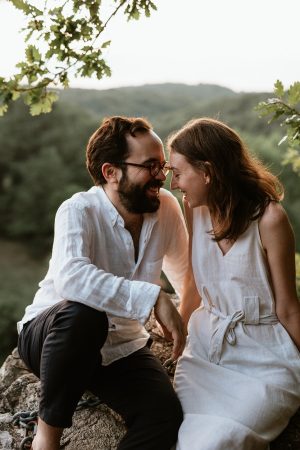 couple sourit assis sur un rocher à Mervent