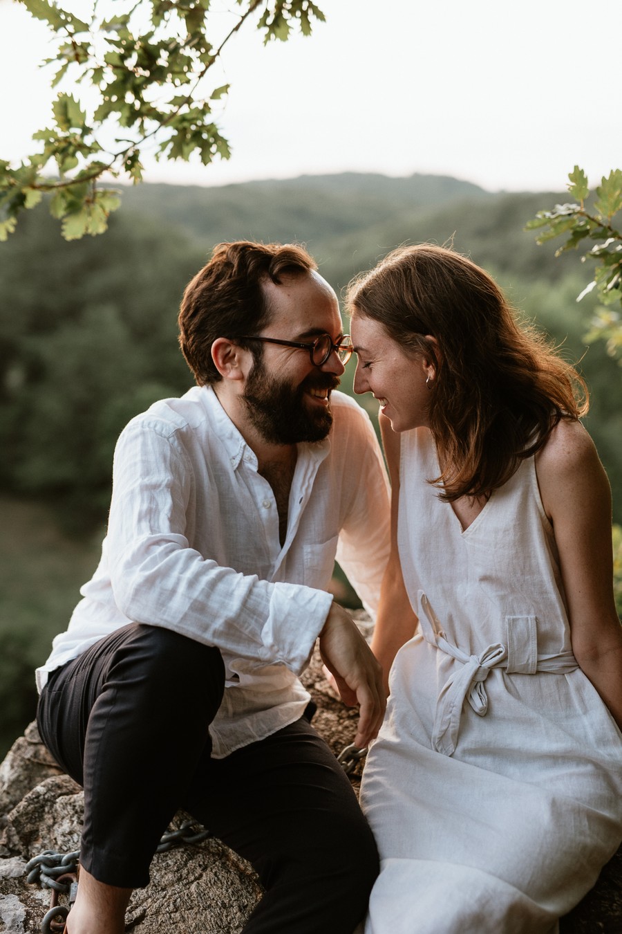 couple sourit assis sur un rocher à Mervent