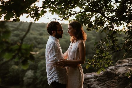Couple se regarde dans les arbres au coucher du soleil