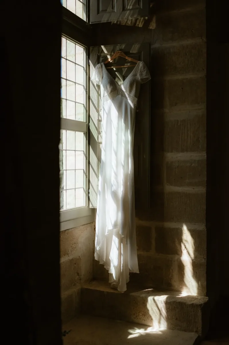 Une robe de mariée éclairée de manière contrastée par le soleil et une fenêtre