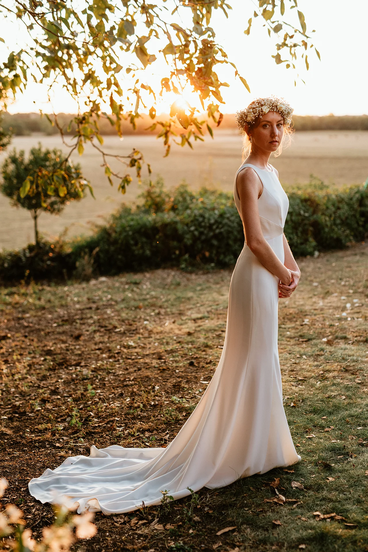 Mariée posant le soir en robe devant le coucher de soleil en Vendée le jour de son mariage